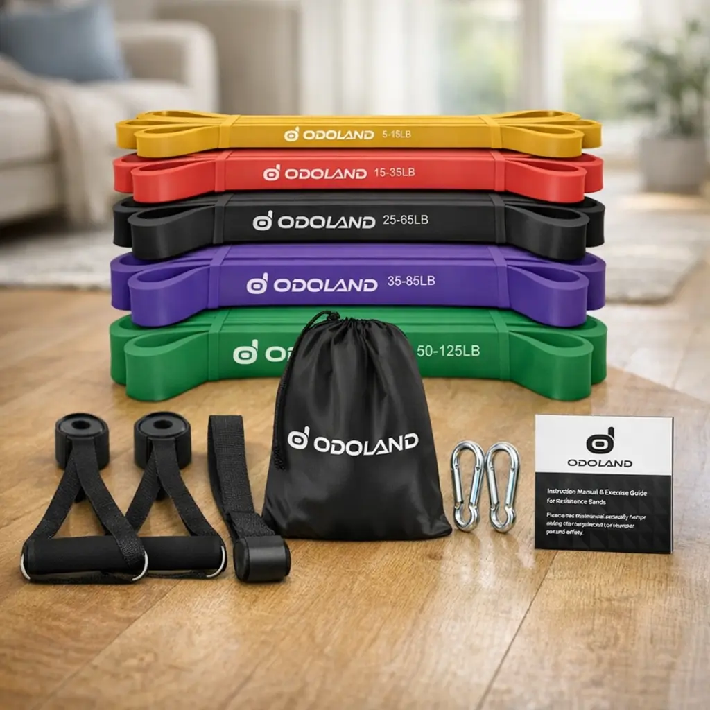 Kit de bandas de resistencia Odoland con cinco bandas, asas, anclaje de puerta, bolsa y mosquetones sobre suelo de salón en casa