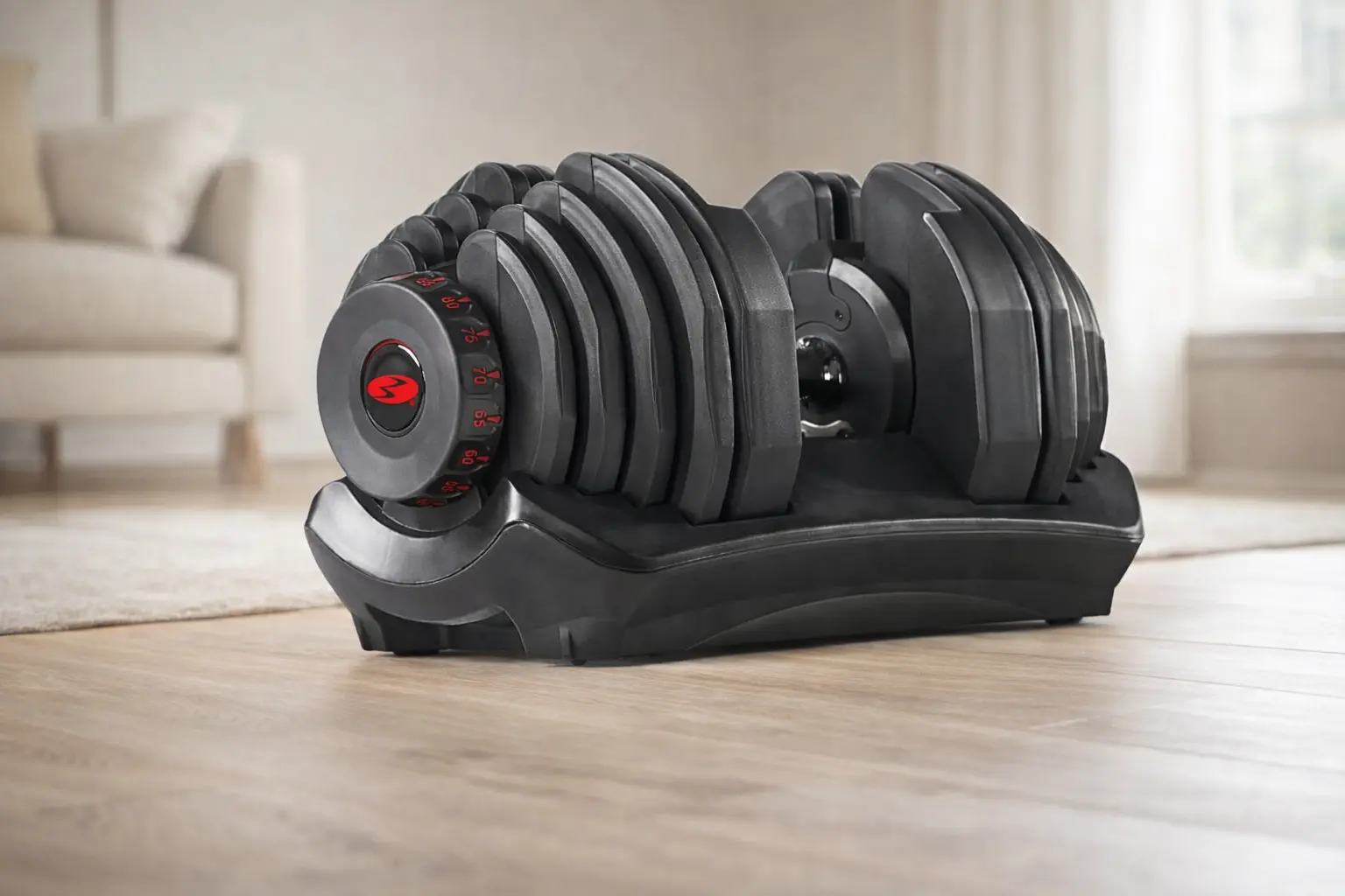 Mancuernas ajustables de 40 kg con dial sobre suelo de madera en salón de casa.